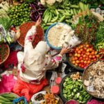 Ilustrasi, seorang wanita menjual bahan pokok di pasar. Foto: Istock @simongurney