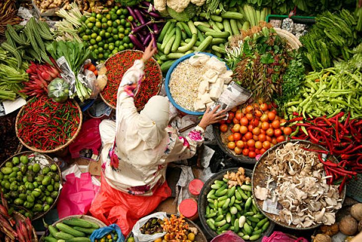 Ilustrasi, seorang wanita menjual bahan pokok di pasar. Foto: Istock @simongurney