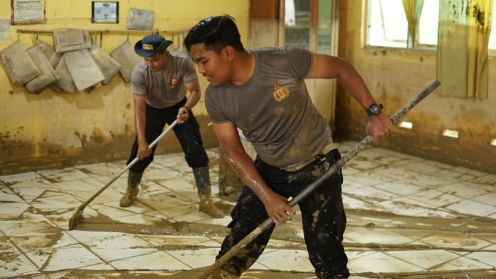 Sejumlah personel Polres Langsa bersama masyarakat melakukan gotong royong membersihkan lingkungan sekolah terdampak banjir di Wilayah Kabupaten Aceh Tamiang, Kamis (25/12/2025). Foto: Ist