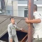 Petugas Satpol PP Kecamatan Pancoran, berupaya mengamankan pria terduga pencuri yang naik ke atap rumah warga di Jalan Pancoran Barat VIII, Pancoran, Jakarta Selatan, Minggu (4/1/2026) siang. Foto: Tangkapan layar Instagram @sekitar_jaksel
