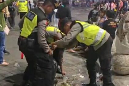 Polisi melakukan aksi bersih-bersih sampah setelah melaksanakan pengamanan malam pergantian tahun di kawasan Titik Nol Kilometer Yogyakarta, Kamis (1/1/2026). Foto: Ist