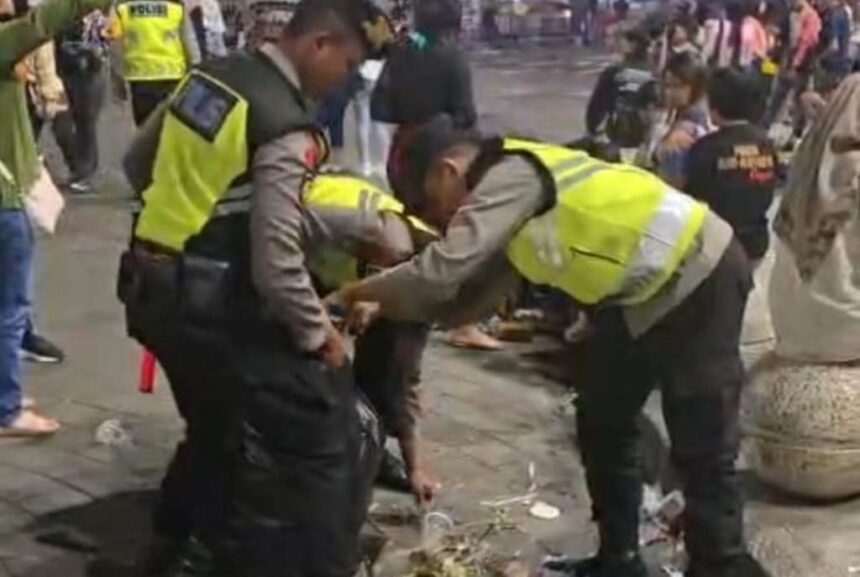 Polisi melakukan aksi bersih-bersih sampah setelah melaksanakan pengamanan malam pergantian tahun di kawasan Titik Nol Kilometer Yogyakarta, Kamis (1/1/2026). Foto: Ist