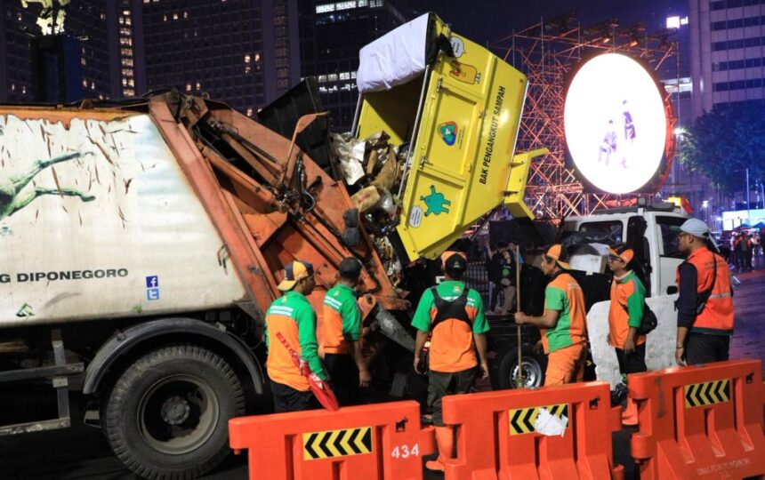 Petugas mengangkut sampah sisa perayaan tahun baru. Foto: Ist