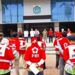 Ketua PMI Kota Jakarta Timur, HR Krisdianto bersama Wali Kota Jakarta Timur, Munjirin, saat mengerahkan 100 personel PPSU untuk menjadi tenaga sukarela PMI Kota membantu pengepakan paket bantuan akan dikirim ke Sumatra, Jumat (2/1/2025).. Foto: Ist