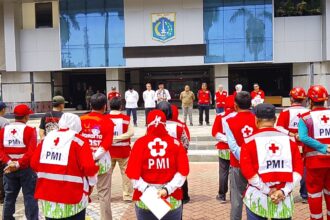 Ketua PMI Kota Jakarta Timur, HR Krisdianto bersama Wali Kota Jakarta Timur, Munjirin, saat mengerahkan 100 personel PPSU untuk menjadi tenaga sukarela PMI Kota membantu pengepakan paket bantuan akan dikirim ke Sumatra, Jumat (2/1/2025).. Foto: Ist