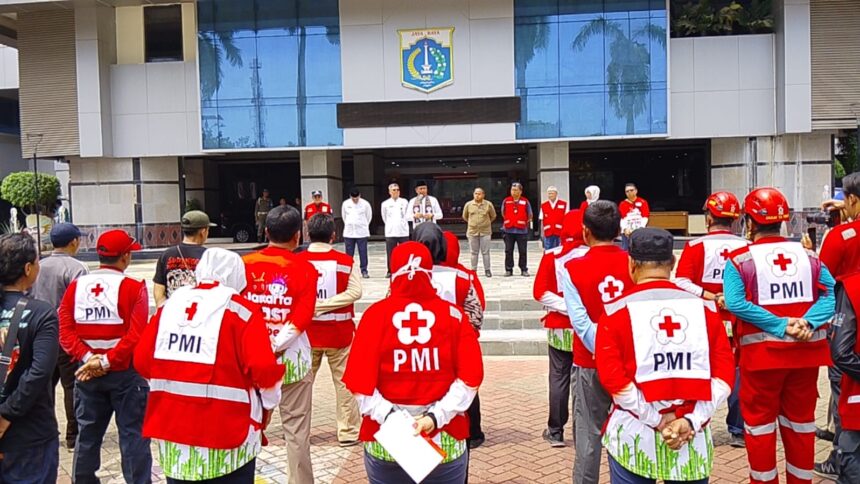 Ketua PMI Kota Jakarta Timur, HR Krisdianto bersama Wali Kota Jakarta Timur, Munjirin, saat mengerahkan 100 personel PPSU untuk menjadi tenaga sukarela PMI Kota membantu pengepakan paket bantuan akan dikirim ke Sumatra, Jumat (2/1/2025).. Foto: Ist