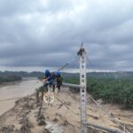 Di tengah kondisi medan yang berlumpur, petugas PLN tetap berjuang mendirikan tower transmisi Pangkalan Brandan-Langsa jalur 2 dengan mengutamakan keselamatan. Foto: Dok PLN