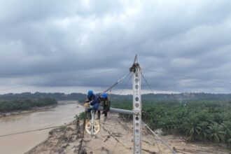 Di tengah kondisi medan yang berlumpur, petugas PLN tetap berjuang mendirikan tower transmisi Pangkalan Brandan-Langsa jalur 2 dengan mengutamakan keselamatan. Foto: Dok PLN