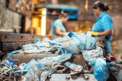 Ilustrasi - Dua pekerja perempuan tengah memilah sampah plastik di tempat pengolahan sampah. Foto: Freepik