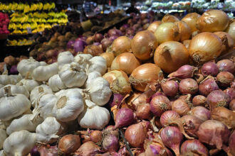Ilustrasi, Bawang putih dan bawang bombay dipajang untuk dijual di pasar kelontong. Foto: Istcok @tylim
