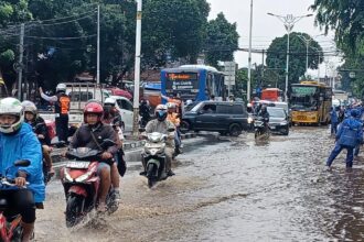 Sejumlah petugas SDA Kecamatan Kramat Jati, Jakarta Timur, mengatur arus lalu lintas yang macet mengular di Jalan Raya Bogor, Kramat Jati mengarah traffick light Pusat Grosir Cililitan, Senin (12/1/2026) siang. Foto: Joesvicar Iqbal/ipol.id