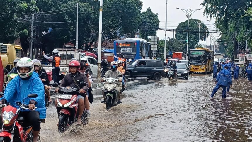 Sejumlah petugas SDA Kecamatan Kramat Jati, Jakarta Timur, mengatur arus lalu lintas yang macet mengular di Jalan Raya Bogor, Kramat Jati mengarah traffick light Pusat Grosir Cililitan, Senin (12/1/2026) siang. Foto: Joesvicar Iqbal/ipol.id