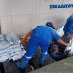 Sejumlah Pasukan Biru Sudin Sumber Daya Air (SDA) Jakarta Selatan, saat membersihkan saluran air yang tersumbat sampah dan lumpur dalam aksi kerja bakti serentak di kawasan Jalan Kapten Tendean, Kebayoran Baru, Jakarta Selatan, Selasa (13/1/2026) pagi. Foto: Joesvicar Iqbal/ipol.id