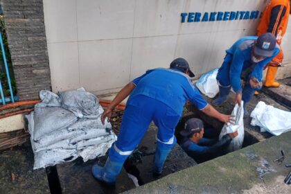 Sejumlah Pasukan Biru Sudin Sumber Daya Air (SDA) Jakarta Selatan, saat membersihkan saluran air yang tersumbat sampah dan lumpur dalam aksi kerja bakti serentak di kawasan Jalan Kapten Tendean, Kebayoran Baru, Jakarta Selatan, Selasa (13/1/2026) pagi. Foto: Joesvicar Iqbal/ipol.id
