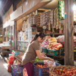 Ilustrasi, seorang pedagang sayur melayani pembeli di pasar Indonesia. Foto: Istcok @primeimages