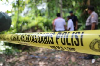 Ilustrasi, Polisi memasang garis pembatas di makam almarhum Sajim (65) di TPU Kampung Gardu Junti, Desa Junti, Kecamatan Jawilan, Kabupaten Serang, Banten, yang diduga dibongkar orang tidak dikenal. Polisi menyelidiki dugaan pencurian tulang jenazah. Foto: Istock @Herwin Bahar