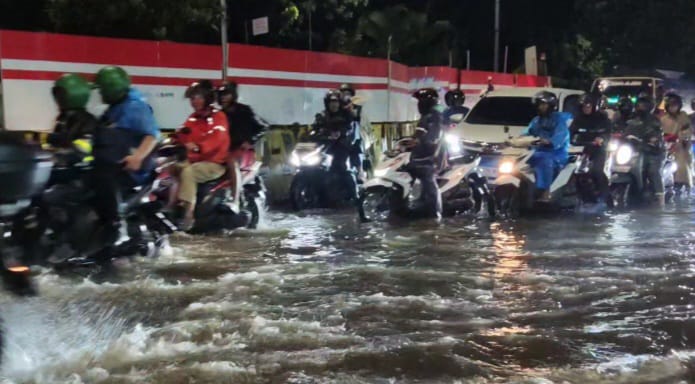 Kondisi ruas Jalan DI Panjaitan, Cawang, Jatinegara, Jakarta Timur, kembali terendam banjir pada Kamis (29/1/2026) malam. Sejumlah kendaraan perlahan antri melintasi genangan. Foto: Joesvicar Iqbal/ipol.id
