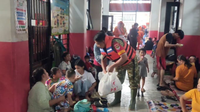 Sejumlah petugas Palang Merah Indonesia (PMI) memberikan bantuan makanan kepada warga terdampak banjir di pengungsian SDN 01-02 Kampung Melayu, Kecamatan Jatinegara, Jakarta Timur, Jumat (30/1/2026). Foto: Joesvicar Iqbal/ipol.id