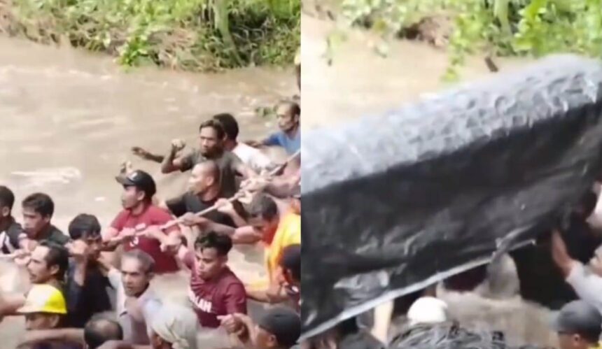 Warga Desa Salube, Kecamatan Loloda Kepulauan, Halmahera Utara, Maluku Utara, bergotong royong menyeberangkan keranda jenazah melewati sungai berarus deras akibat jembatan menuju area pemakaman ambruk diterjang banjir, Senin (12/1/2026). Foto: TikTok @pardidu.tabalai