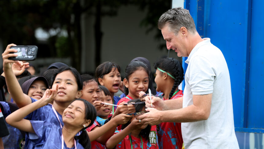 Pelatih Kepala MilkLife Soccer Challenge Timo Scheunemann saat memberikan tanda tangan kepada para peserta MLSC Bandung Seri 2 2025 - 2026. Foto/Megapro