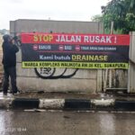 Warga membentangkan spanduk bertuliskan protes terhadap pengurukan lahan.(foto sofian/ipol.id).