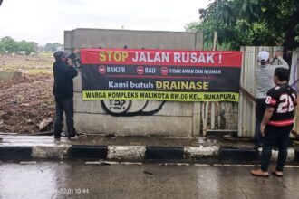 Warga membentangkan spanduk bertuliskan protes terhadap pengurukan lahan.(foto sofian/ipol.id).