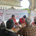 Petugas medis AdMedika dan TelkoMedika melakukan pemeriksaan tekanan darah kepada warga terdampak banjir dan tanah longsor di Mesjid Bandar Mahligai, Desa Bandar Magligai, Kec Sekerak, Aceh Tamiang, Jumat (9/1). Foto: Telkom Indonesia