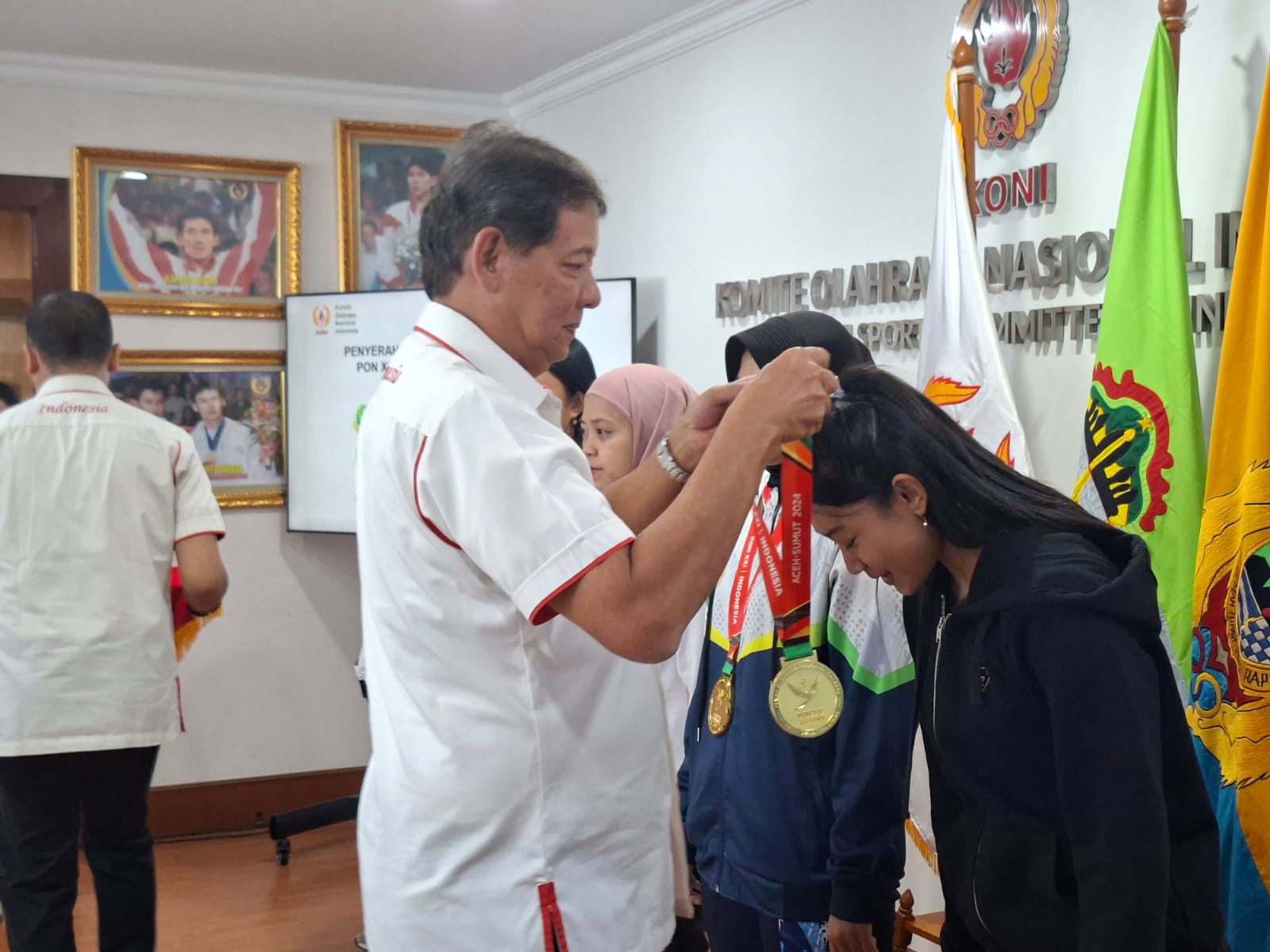Sekjen KONI Ade Lukman memberikan medali perunggu kepada  atlet kickboxing  Jawa Tengah dan Chavella Teyza Putri Budayana. Foto/Ipol