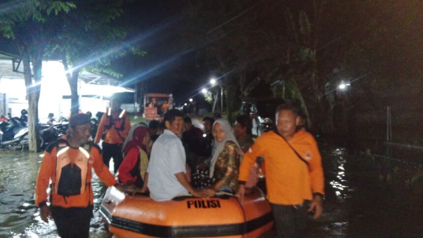 Petugas BPBD Kabupaten Grobogan mengevakuasi warga dari banjir menggunakan perahu karet di Desa Tinanding, Kecamatan Godong, Kabupaten Grobogan, Jawa Tengah, Senin (16/2/2026) malam. Foto: Ist