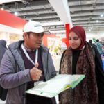 Petugas Kemenag menjelaskan Mushaf Alquran Isyarat pertama di dunia kepada pengunjung booth Indonesia. Foto: Kemenag
