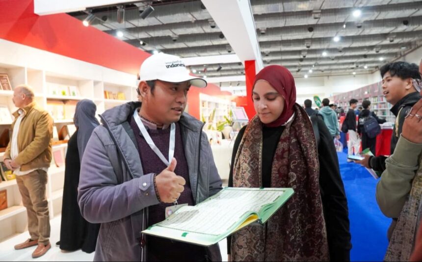 Petugas Kemenag menjelaskan Mushaf Alquran Isyarat pertama di dunia kepada pengunjung booth Indonesia. Foto: Kemenag