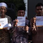 Warga terdampak bencana menunjukan buku tabungan berisi dana perbaikan rumah dari pemerintah di halaman Kantor Wali Kota Lhoksumawe, Provinsi Aceh, Jumat (13/2/2026). Foto: Ist