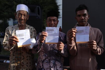 Warga terdampak bencana menunjukan buku tabungan berisi dana perbaikan rumah dari pemerintah di halaman Kantor Wali Kota Lhoksumawe, Provinsi Aceh, Jumat (13/2/2026). Foto: Ist