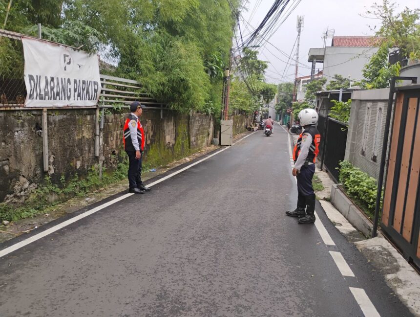 Sejumlah petugas Dinas Perhubungan menjaga lokasi parkir liar di Jalan Damai, RT 02/01, Kelurahan Kalisari, Pasar Rebo, Jakarta Timur, yang kini sudah steril, Senin (6/4/2026). Empat mobil yang semula terparkir kini sudah tidak ada lagi. Foto: Ist