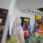 Ilustrasi petugas PLN tengah berinteraksi dengan pelanggan sebelum melakukan proses penambahan daya listrik di rumah pelanggan. Foto: PLN