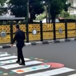 Pengguna jalan melintasi zebra cross kreatif buatan warga di Jalan Soepomo, kawasan Pancoran–Tebet, Jakarta Selatan. Foto: IG @jakata.keras