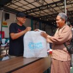 Tampak personel Yayasan Baitul Maal PLN menyerahkan sedekah daging kepada penerima manfaat, salah satu pengurus panti asuhan di Surabaya. Foto: Dok PLN