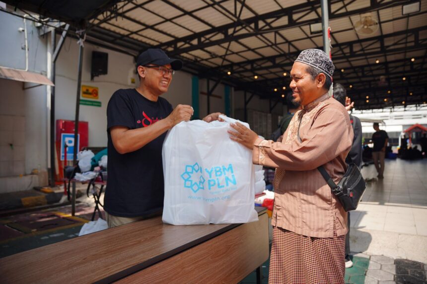 Tampak personel Yayasan Baitul Maal PLN menyerahkan sedekah daging kepada penerima manfaat, salah satu pengurus panti asuhan di Surabaya. Foto: Dok PLN