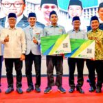 Menko Pangan Zulkifli Hasan menyerahkan kartu BPJS Ketenagakerjaan kepada guru ngaji. Foto: Ist