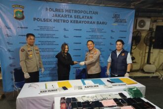 Kapolsek Metro Kebayoran Baru, AKBP Nugrahadi Kusuma didampingi Kanit Reskrim, AKP Andre J R Simamora, dan Kasi Humas Polres Metro Jakarta Selatan, AKP Joko Adi, menyerahkan iPhone 11 Pro yang dicuri kepada pemiliknya, di Mapolsek Kebayoran Baru, Jakarta Selatan, Jumat (8/5/2026). Foto: Joesvicar Iqbal/ipol.id