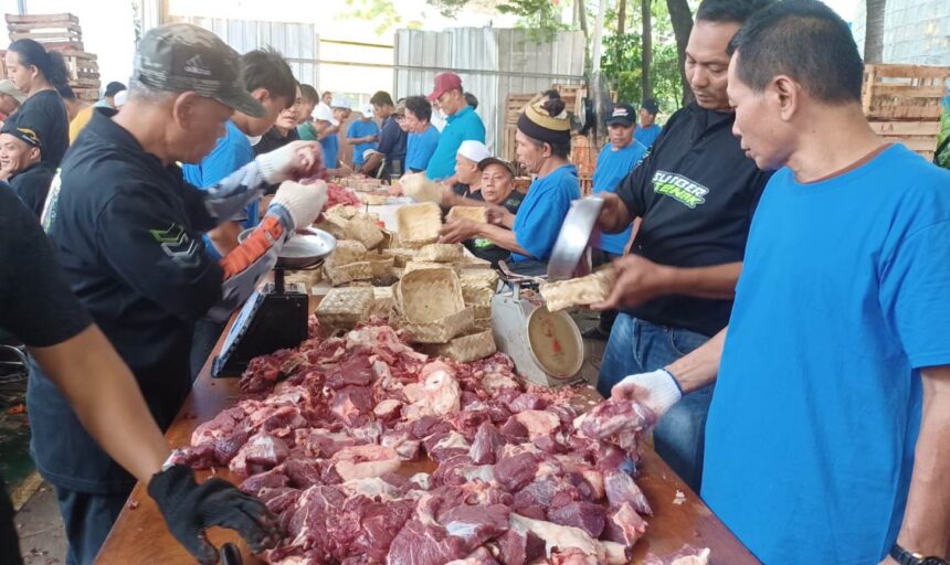 Panitia kurban melakukan pengemasan daging menggunakan besek bambu untuk dibagikan kepada warga sekitar di Pasar Induk Kramat Jati, Jakarta Timur, Kamis (28/5/2026). Foto: Joesvicar Iqbal/ipol.id