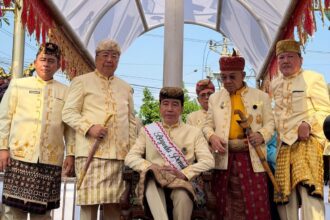 Jokowi menerima gelar adat di Lampung dengan simbolisasi menginjak kepala kerbau di kakinya. Foto: Dok X @DianSandiU