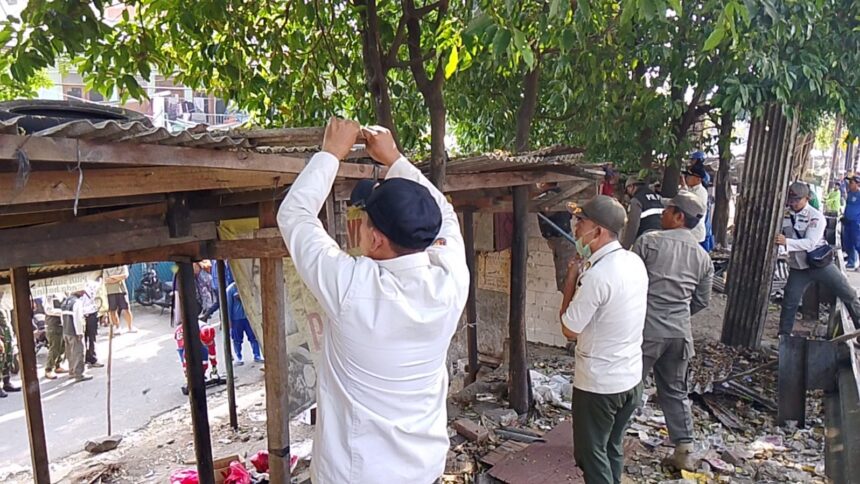 Petugas menertibkan bangunan liar dan lapak pedagang di pinggir Jalan Kerja Bakti, RT 01/02, Kelurahan Makasar, Kecamatan Makasar, Jakarta Timur, Rabu (15/7/2026). Foto: Ist