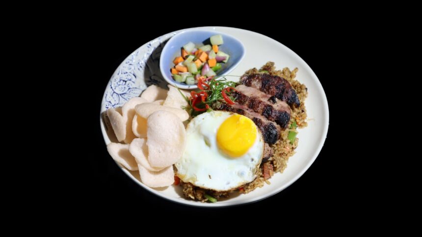 Nasi Goreng Steak, perpaduan nasi goreng khas Indonesia dengan potongan steak yang juicy, disajikan bersama telur mata sapi, acar segar, dan pelengkap yang menggugah selera. (istimewa/dok. Canting Restaurant, Vasaka Hotel Jakarta).